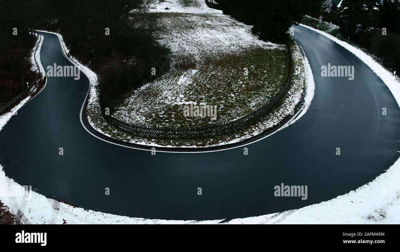 Haarnadelkurve einer Landstraße in die winterliche Eifel Stockfoto