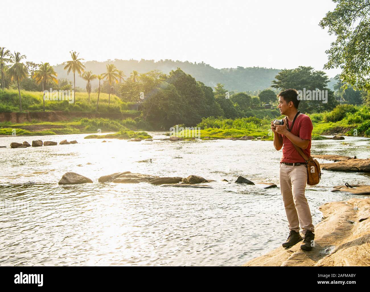Mann unter Bild auf seine analogen Abstandsmesser Kamera in Pinnawala Stockfoto