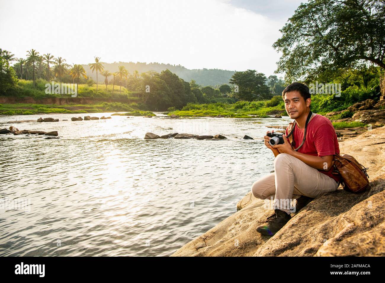 Mann unter Bild auf seine analogen Abstandsmesser Kamera in Pinnawala Stockfoto