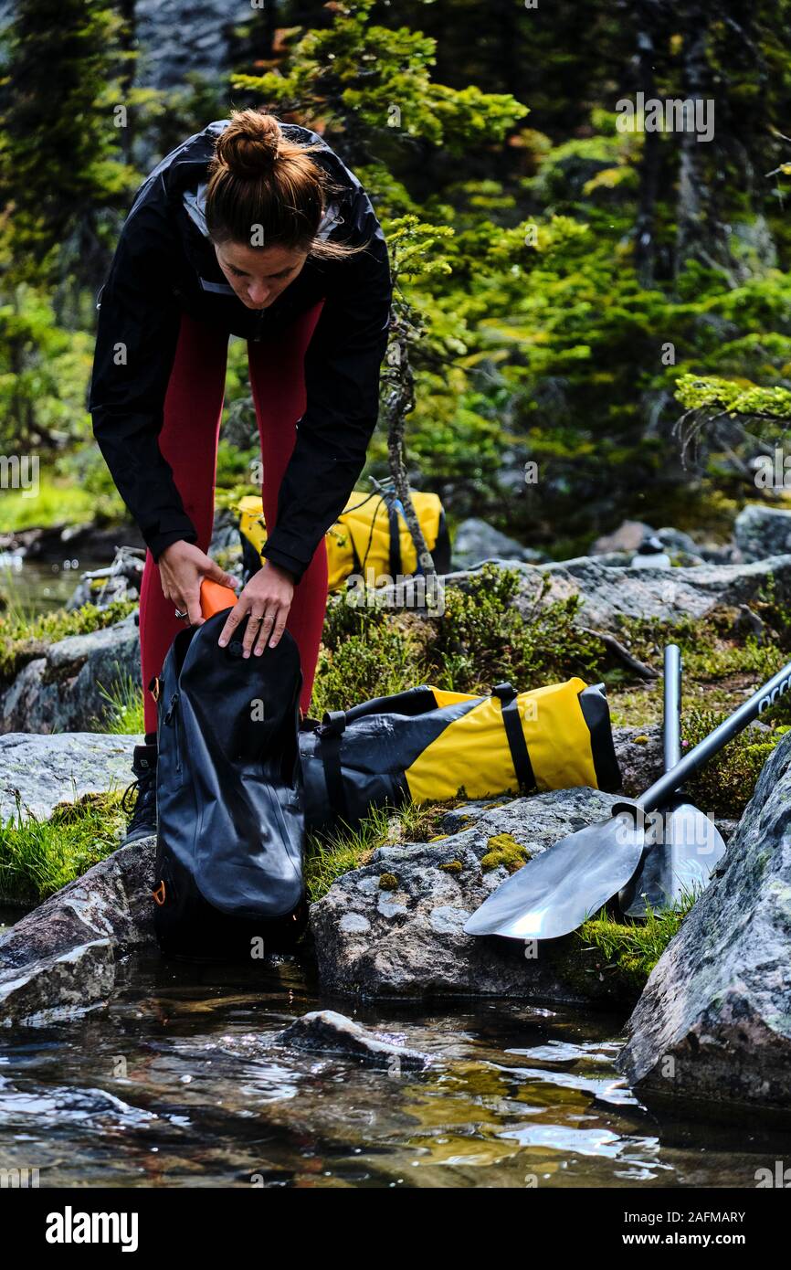 Eine Frau packt Ihr Gang vorbereitet über Cirque See packrat. Stockfoto