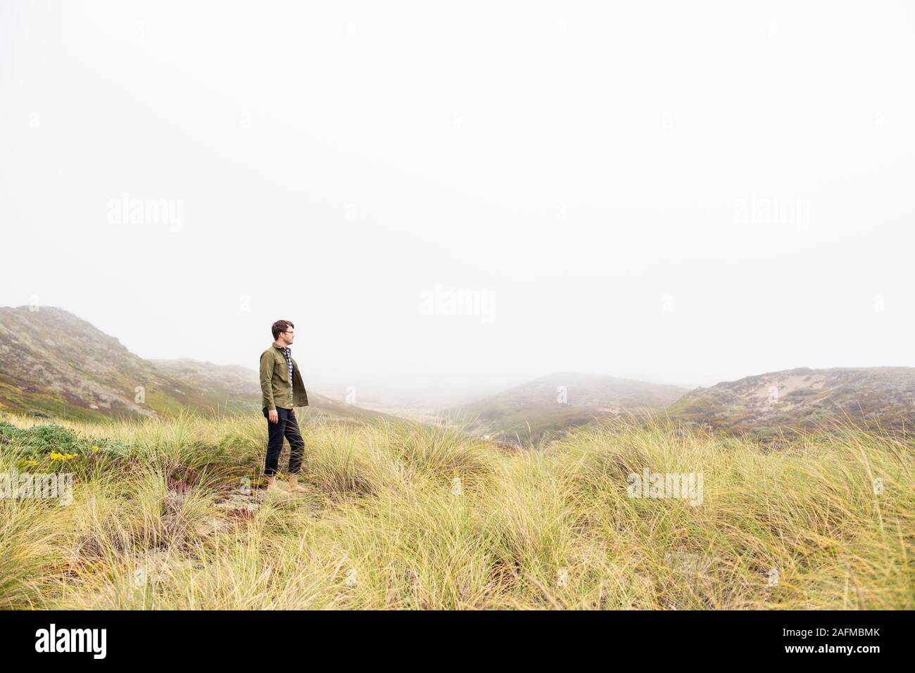Junge Mann in Bereich der Sea Grass an der Küste Stockfoto