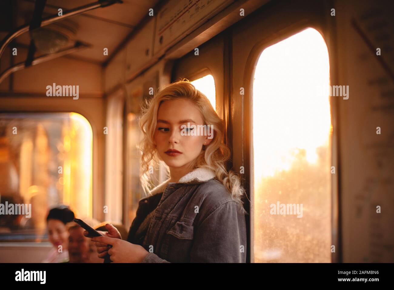 Junge Frau mit smart phone unterwegs in der U-Bahn Stockfoto
