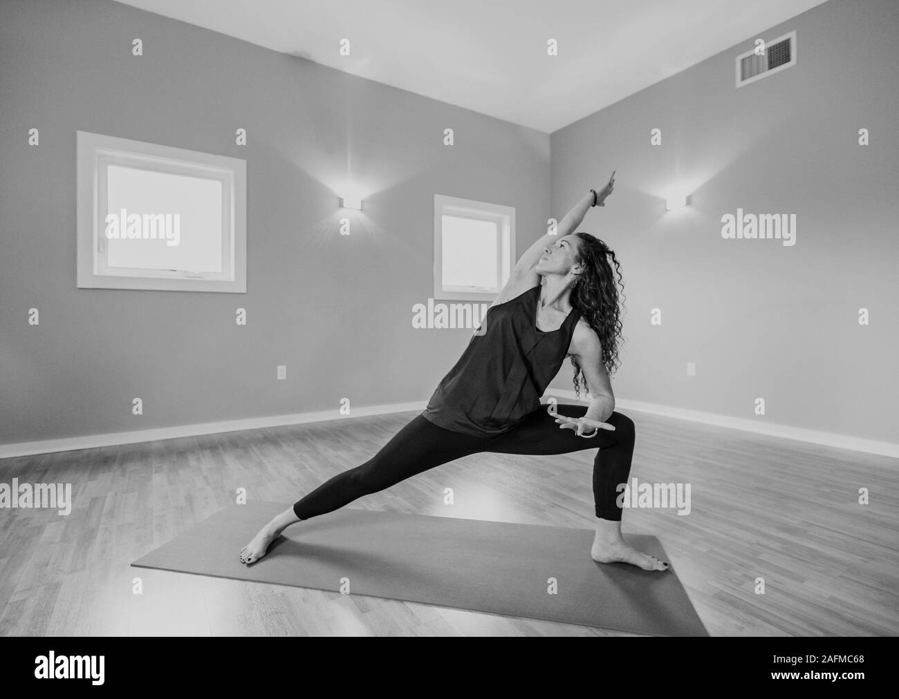Schwarz-weiß-Bild im mittleren Alter Frau Yoga in einem Studio Stockfoto