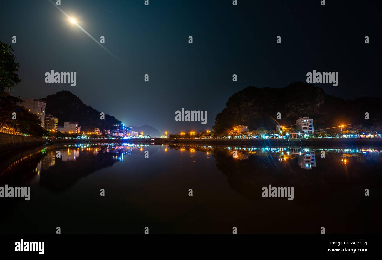 Cat Ba Vietnam Vollmond Nacht Stadtzentrum Reflexion im Wasser Stockfoto