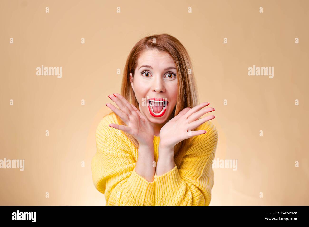 Bild von überrascht Frau mit Brille und in gelb Pullover über der Hintergrund gelb gekleidet. An der Kamera schauen. Stockfoto