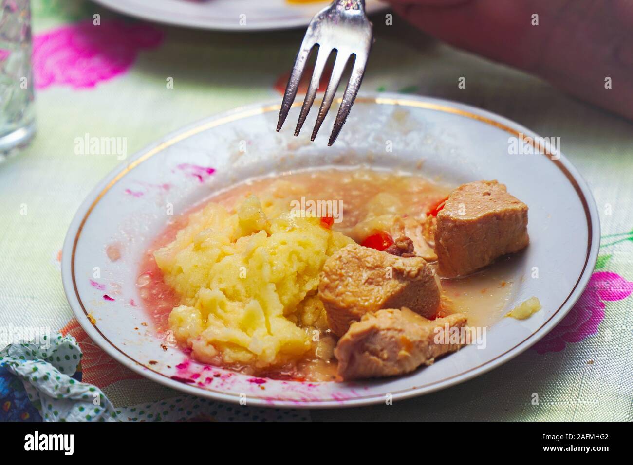 Halb gegessen Essen in einer Platte - Kartoffeln und Fleisch. Speisereste. Selektiver Fokus Stockfoto