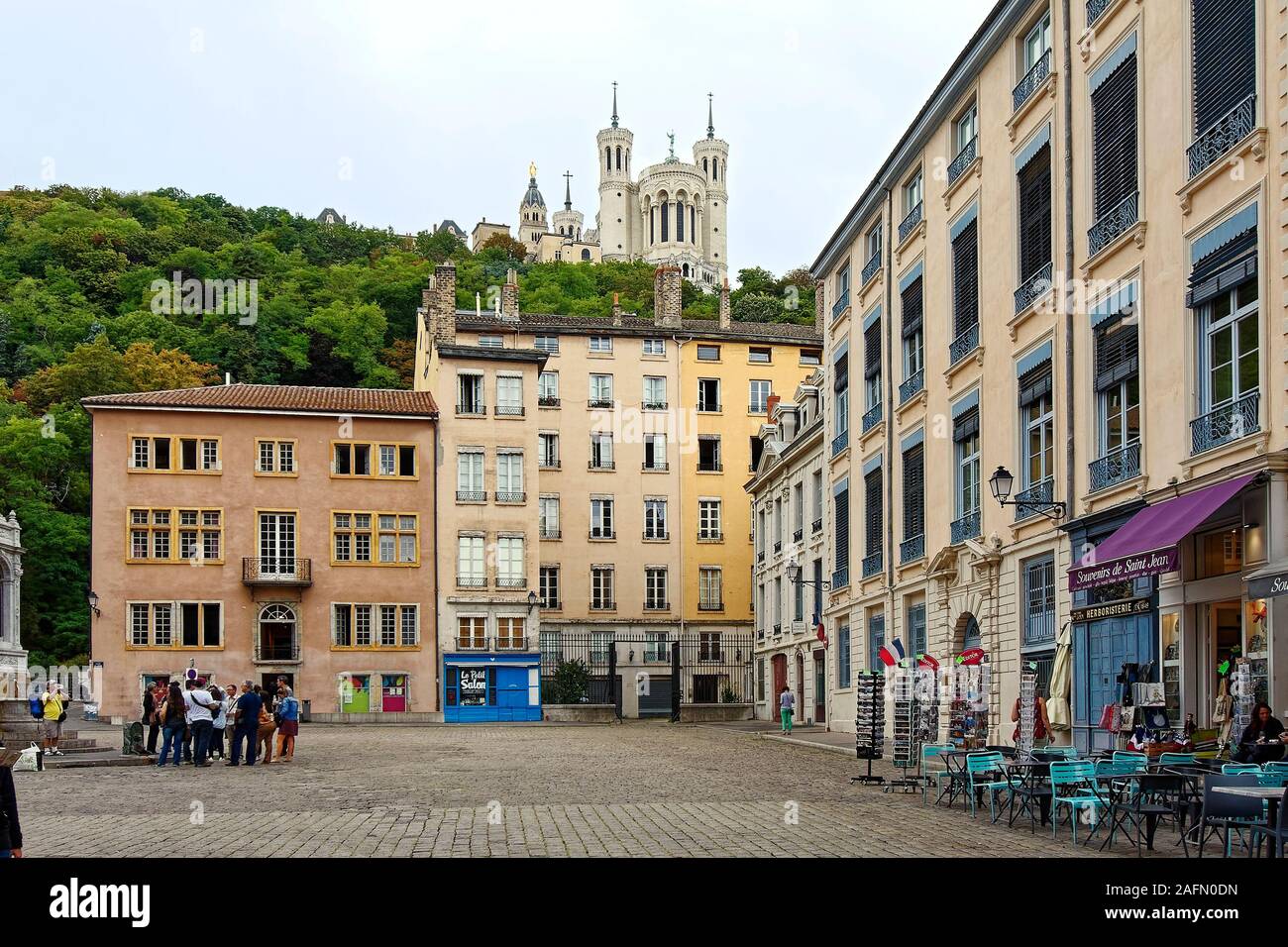 St. Jean Square, Notre Dame De Fourviere Basilica oben, alte Gebäude, Kopfsteinpflaster, Menschen, Hügel, Bäume, street scene, Stadtbild, Tische im Freien Stockfoto