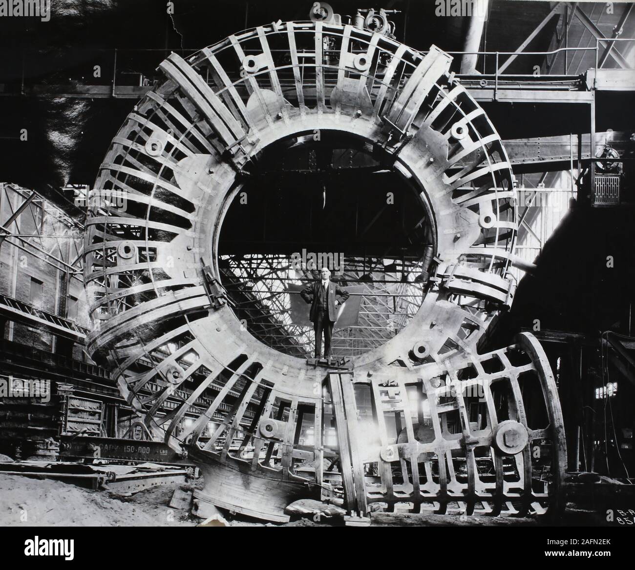 Ein Geschäftsführer der Gesellschaft steht in der Mitte einer Gussform für eine Gießerei Fabrik, Ca. 1930. Stockfoto