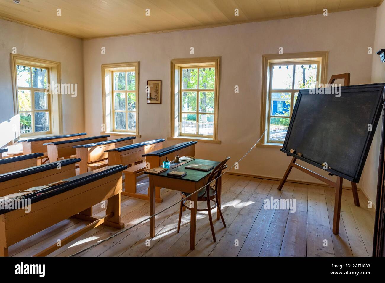 Alte traditionelle Klassenzimmer der frühen 1900er Jahre mit Holzmöbeln mit Sonnenlicht die Windows Stockfoto