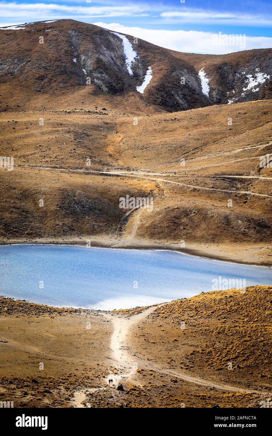 Ein paar Wanderer sind von der Landschaft in der Nähe des Lago de la Luna, Nevado de Toluca, Mexiko in den Schatten gestellt. Stockfoto