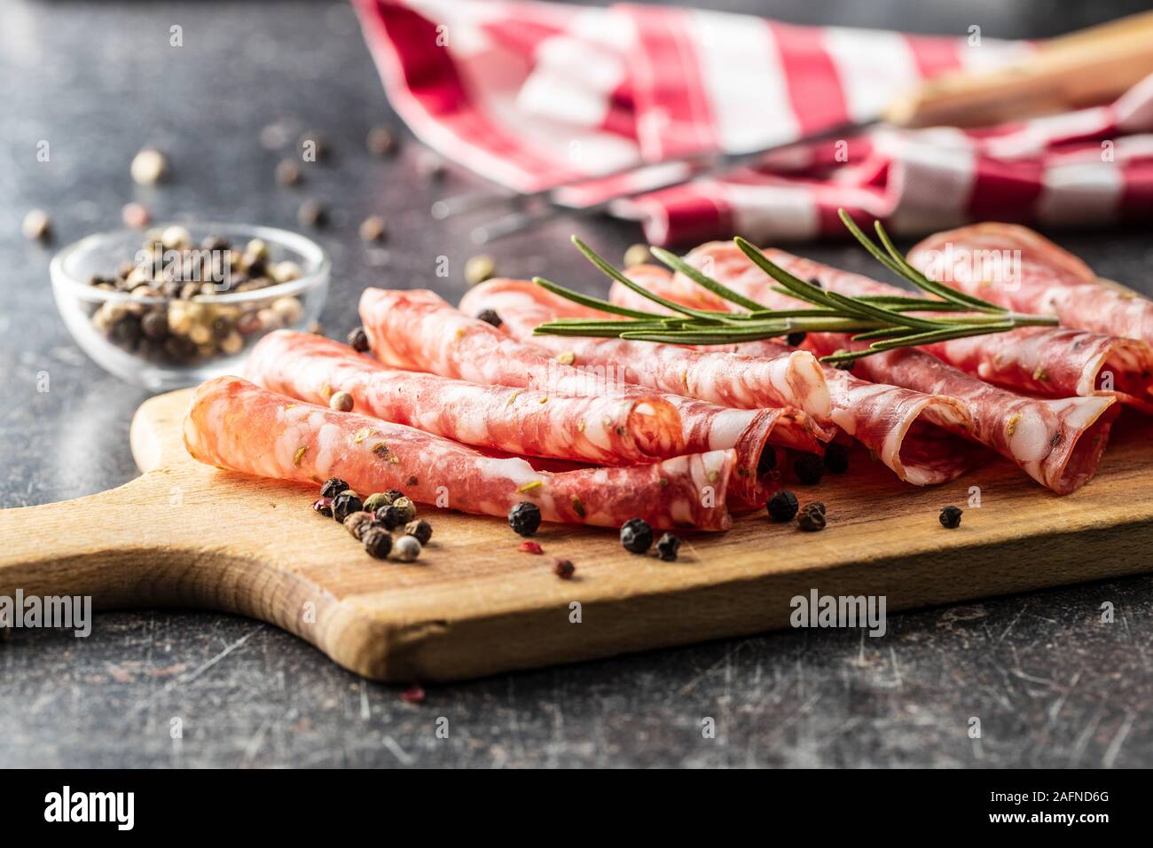 Salami in Scheiben geschnitten. Wurst Fleisch mit Pfeffer und Rosmarin. Stockfoto