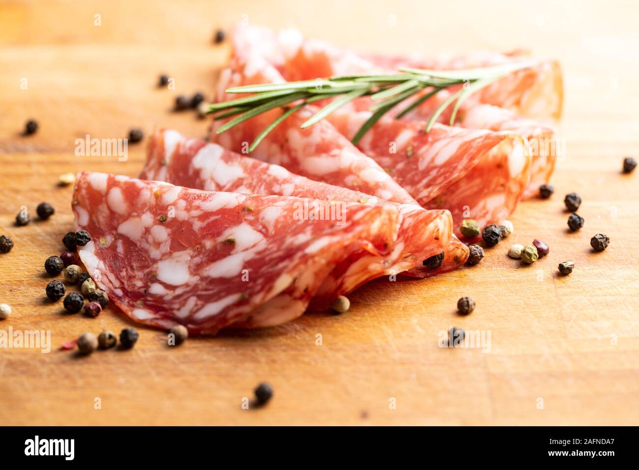 Salami in Scheiben geschnitten. Wurst Fleisch mit Pfeffer und Rosmarin. Stockfoto