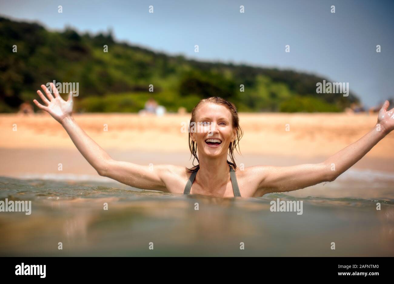 Mitte der erwachsenen Frau genießt das Schwimmen im Meer. Stockfoto