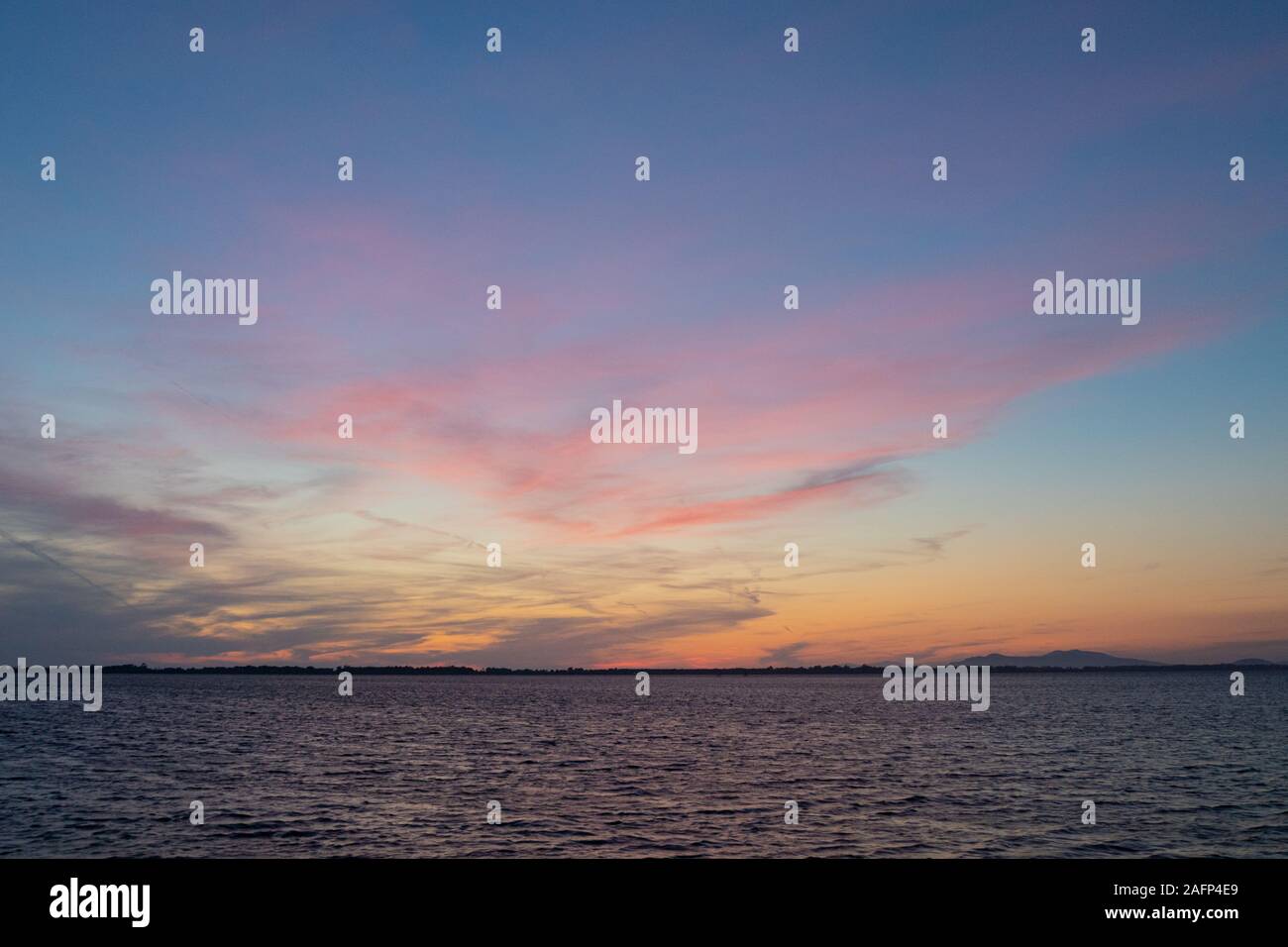 Sonnenuntergang auf der Lagune von Orbetello in der Toskana in der Nähe von Monte Argentario mit bunten Himmel und Meer Stockfoto