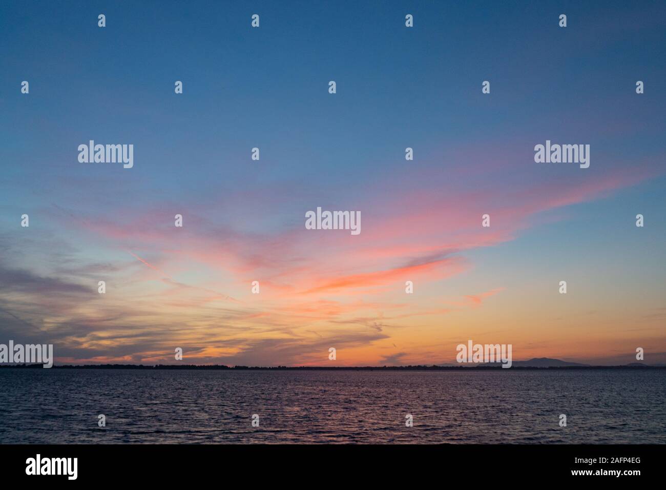 Sonnenuntergang auf der Lagune von Orbetello in der Toskana in der Nähe von Monte Argentario mit bunten Himmel und Meer Stockfoto