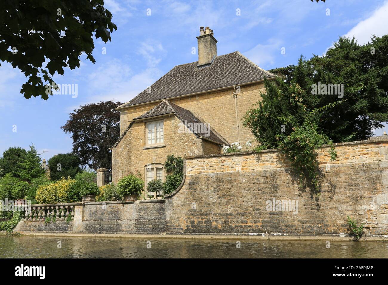 Der River Windrush fließt an einem malerischen Steingebäude bei Bourton-on-the-River im Gebiet der Cotswolds im Süden Mittelenglands vorbei. Stockfoto