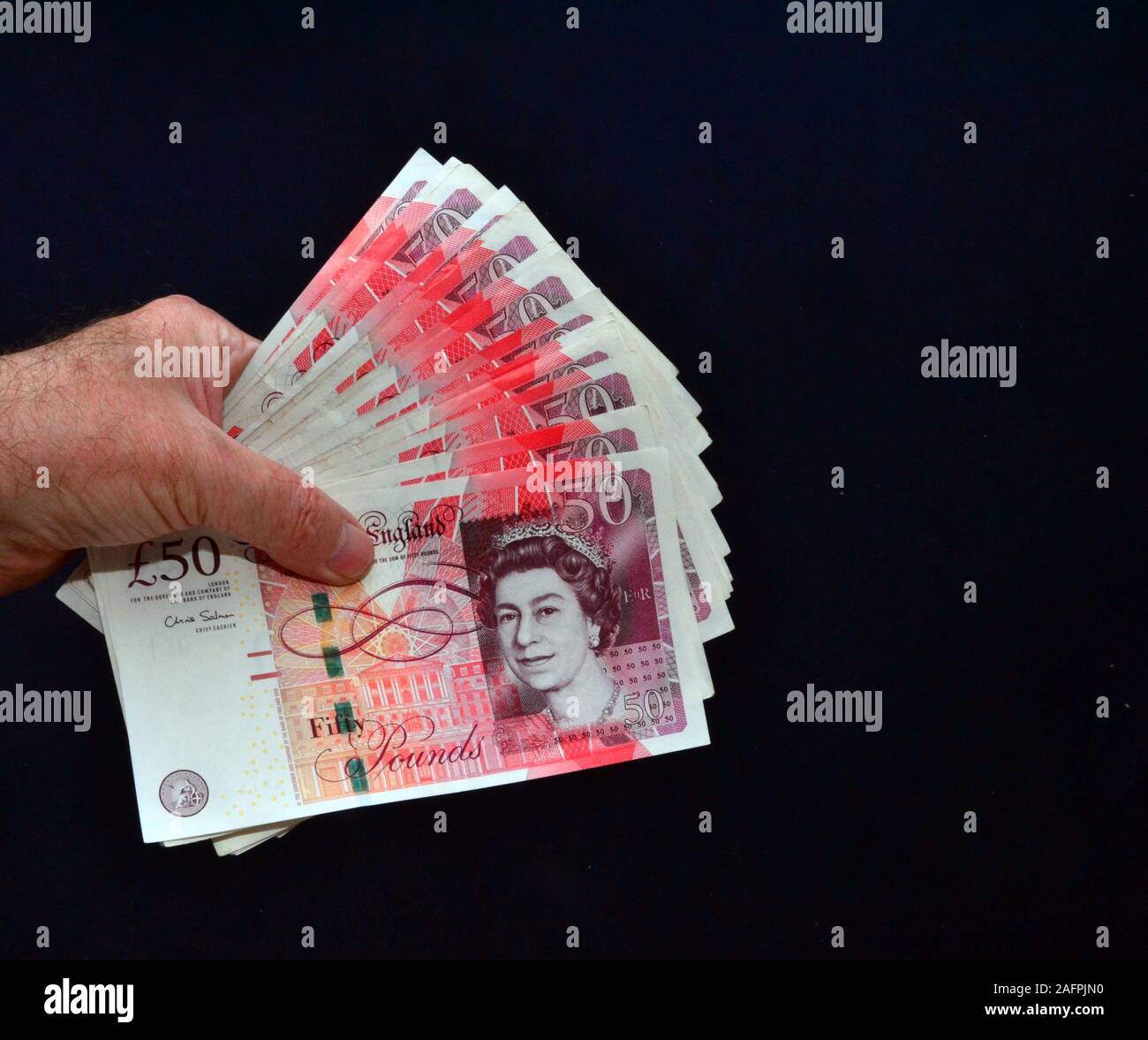 Des Menschen Hand hält eine Reihe von £ 50 Britische Banknoten Stockfoto