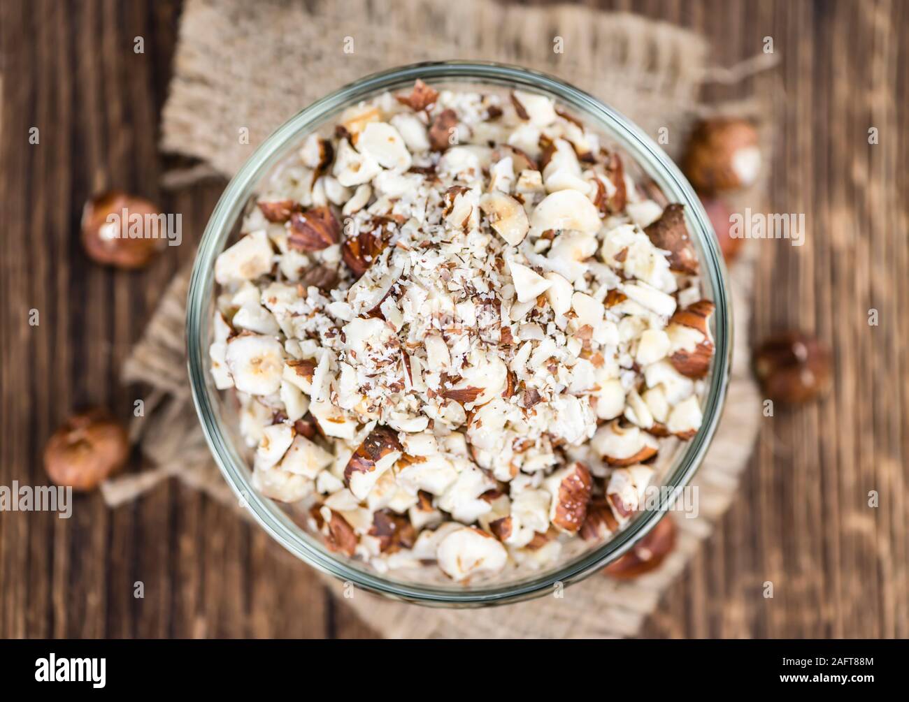 Holztisch mit gehackten Haselnüssen (selektive Fokus, Nahaufnahme) Stockfoto