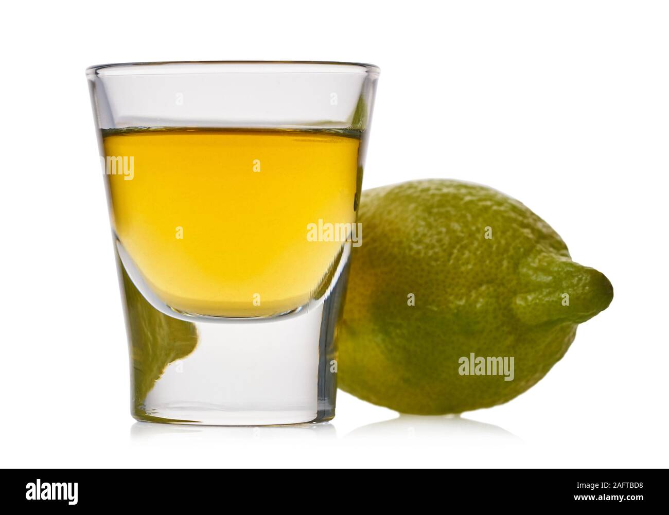 Glas mit starken alkoholischen Getränk und Zitronen auf weißem Hintergrund isoliert Stockfoto