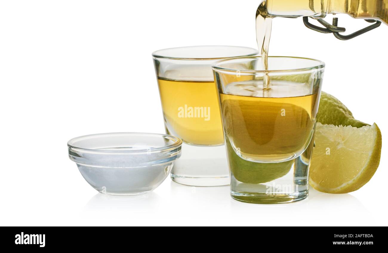Starkes Getränk wird in ein Glas gegossen auf weißem Hintergrund isoliert Stockfoto
