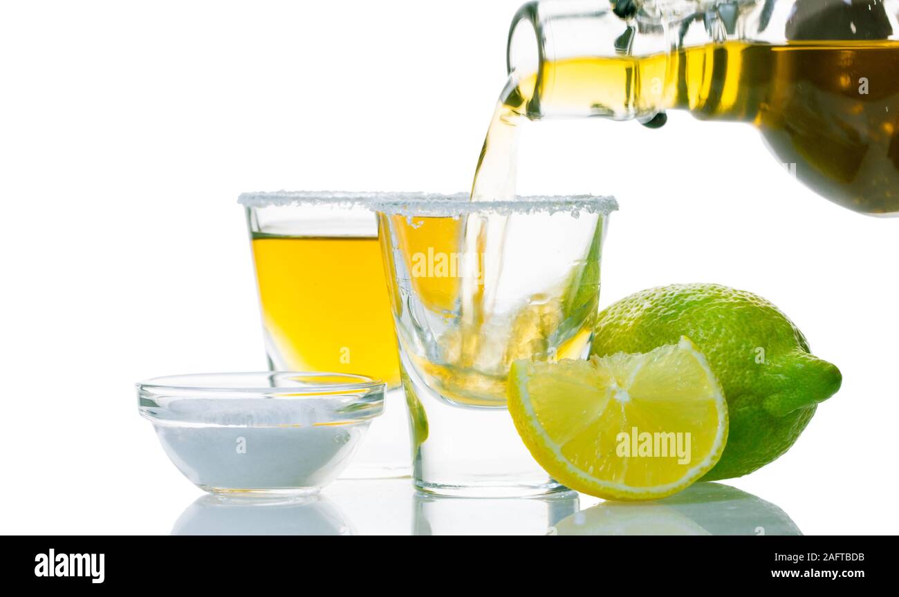 Starkes Getränk wird in ein Glas gegossen auf weißem Hintergrund Stockfoto