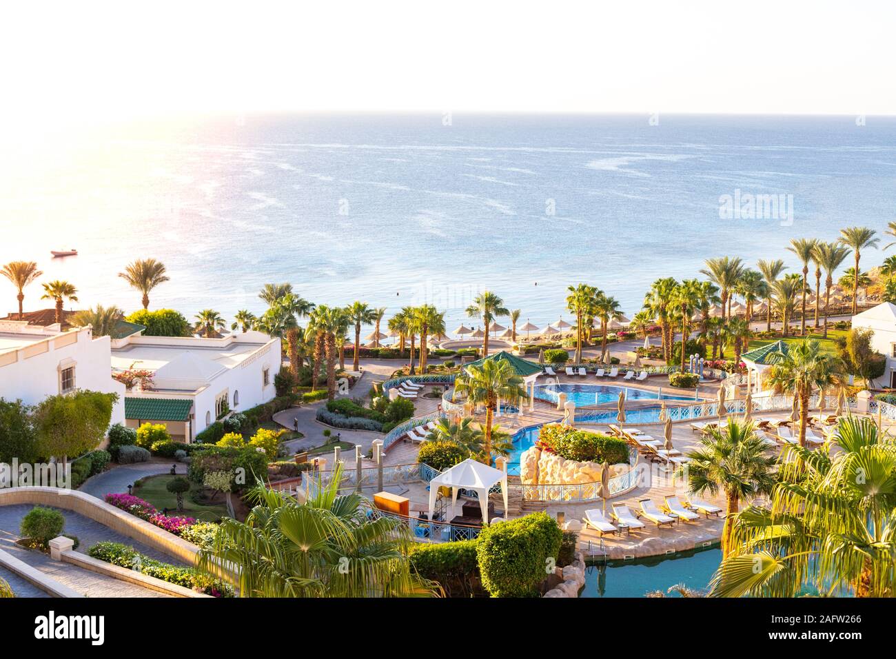 Luxuriöse Hotelanlage. Der Landschaftsgestaltung und der Pool mit Sonnenliegen und Blick auf das Meer. Üppiges Grün und tropischen Bäumen. High Class Seaside Resort. Stockfoto