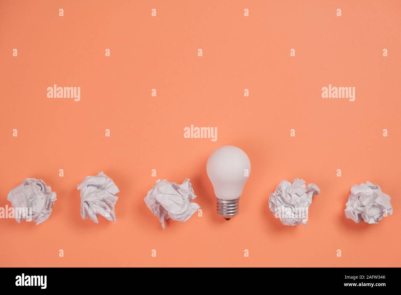 Kreativität, Inspiration, gute Geschäftsidee Konzept mit weißem Licht Lampe und Papier Kugel auf orangefarbenem Hintergrund zerknittert. Flach, Ansicht von oben, kopieren Raum Stockfoto