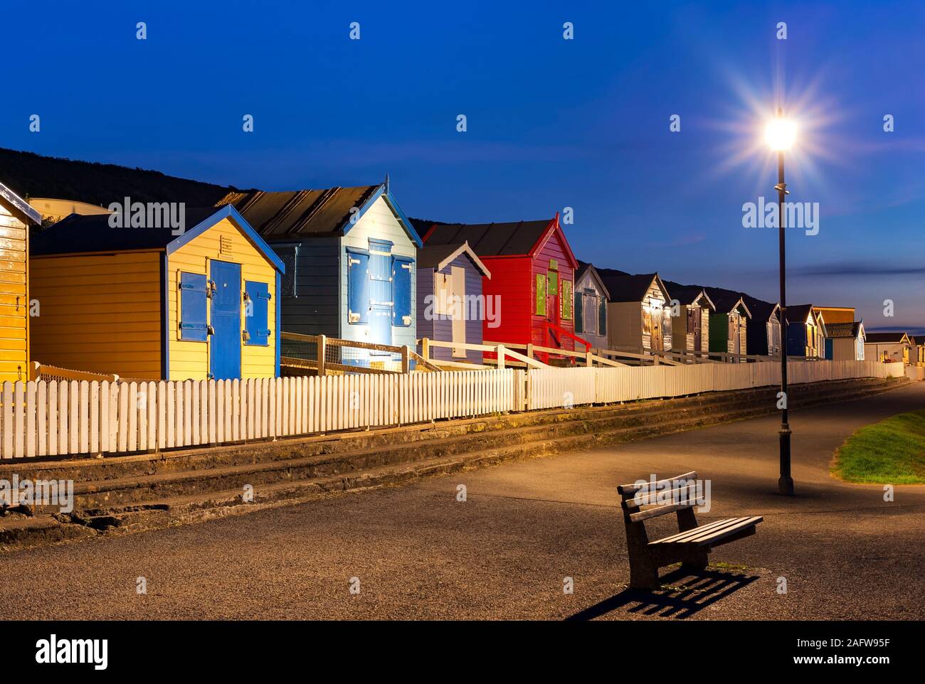 Bunte Strandhütten an der Promenade in Westward Ho!, alle Urlaubsziele, Eimer und Spaten Urlaub, Freizeit, Tag, North Devon, Abendlicht Stockfoto