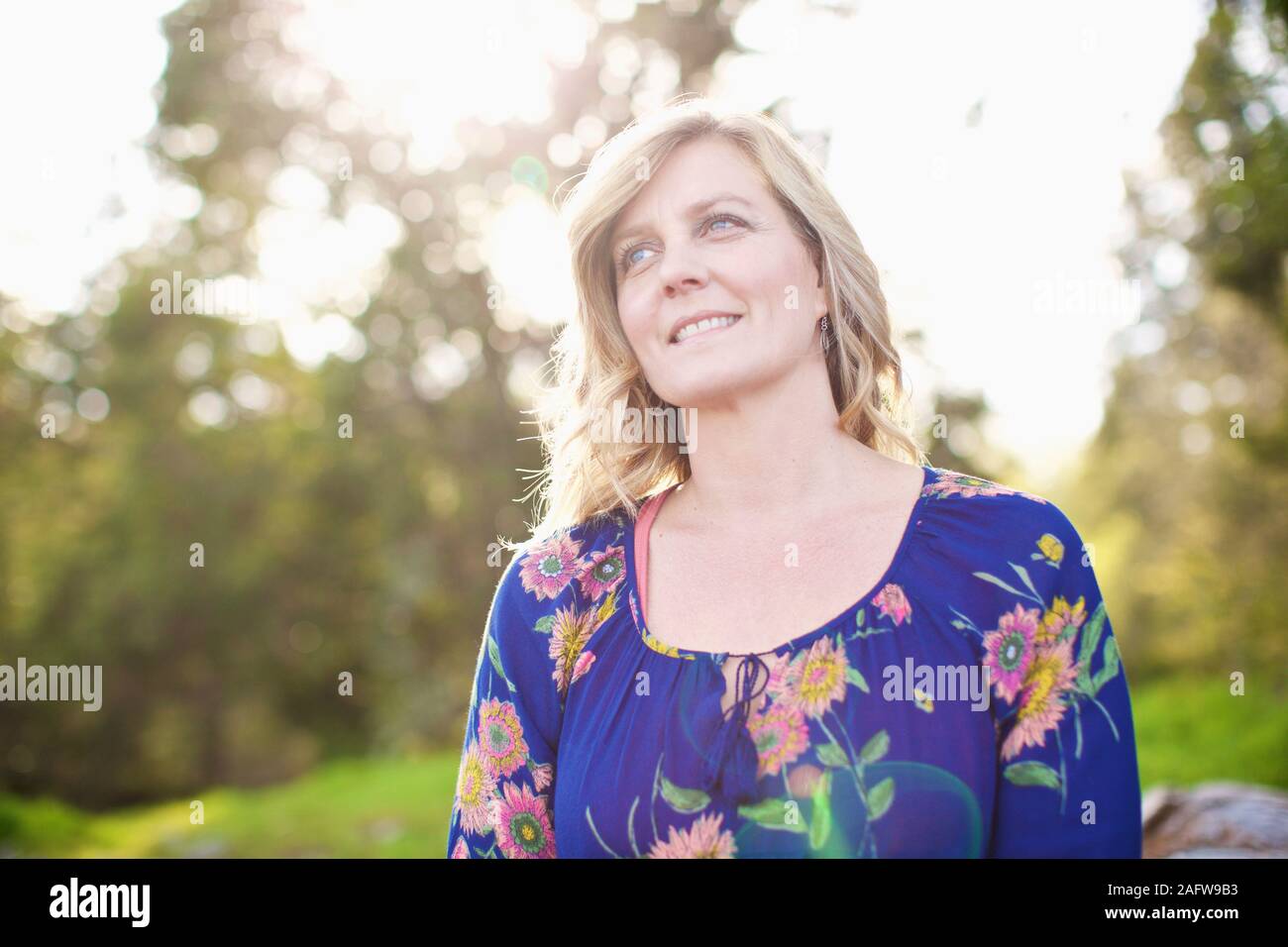 Porträt Lächeln, ruhige Frau im sonnigen Park Stockfoto