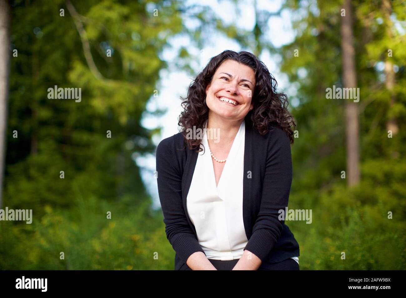 Portrait zuversichtlich, glückliche Frau in Wäldern lächeln Stockfoto