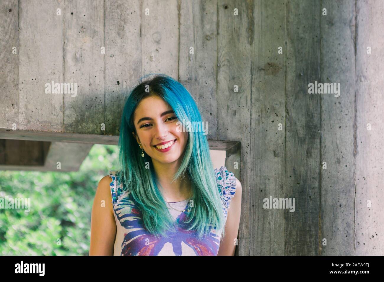 Portrait lächelnden jungen Frau mit blauen Haaren Stockfoto