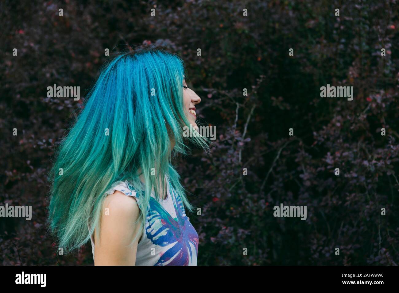 Profil unbeschwerte junge Frau mit blauen Haaren Stockfoto