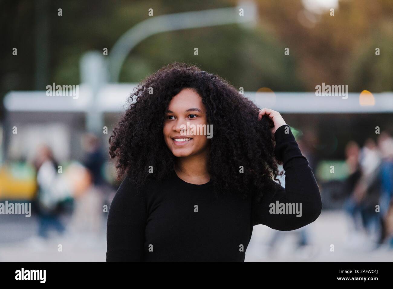 Portrait selbstbewussten jungen Frau mit Hand in Haar auf Urban Street Stockfoto