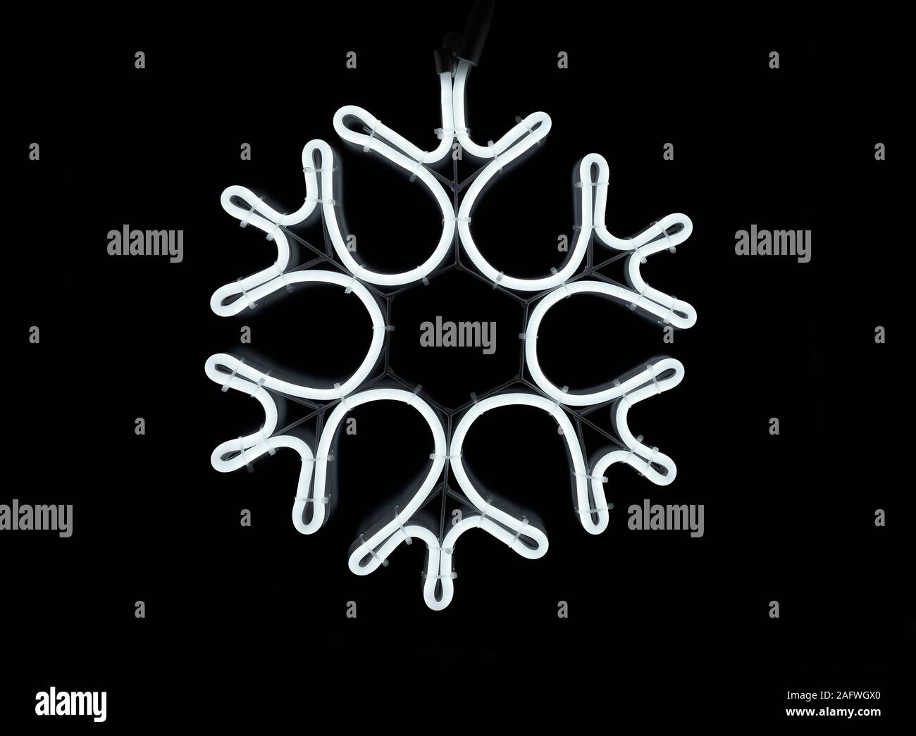 Neon-effekt Schneeflocke Weihnachten dekoratives Licht auf schwarzem Hintergrund Stockfoto