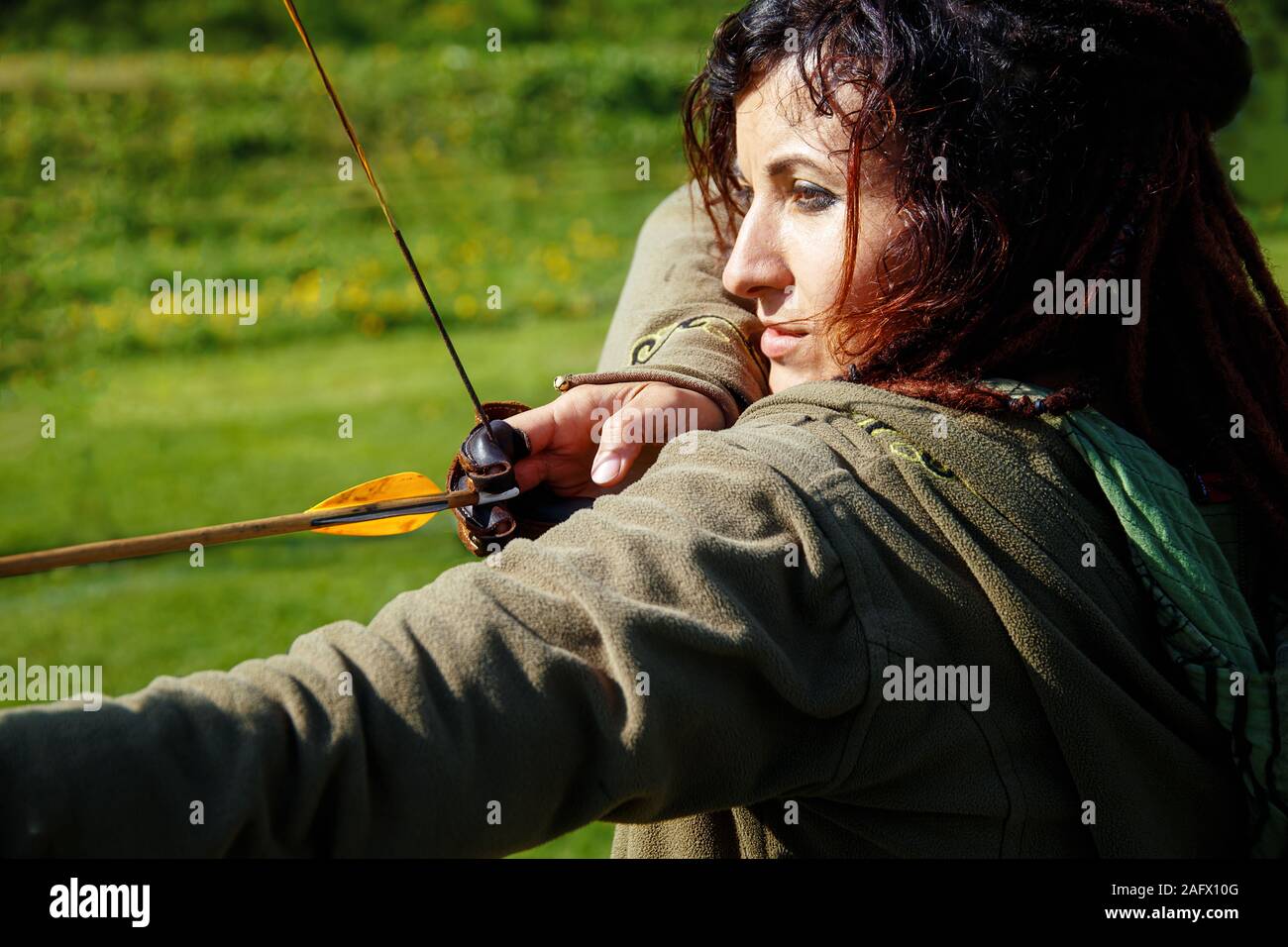 Detail einer Frau Ausbildung schießen mit einem Bogen auf der Wiese, Stockfoto