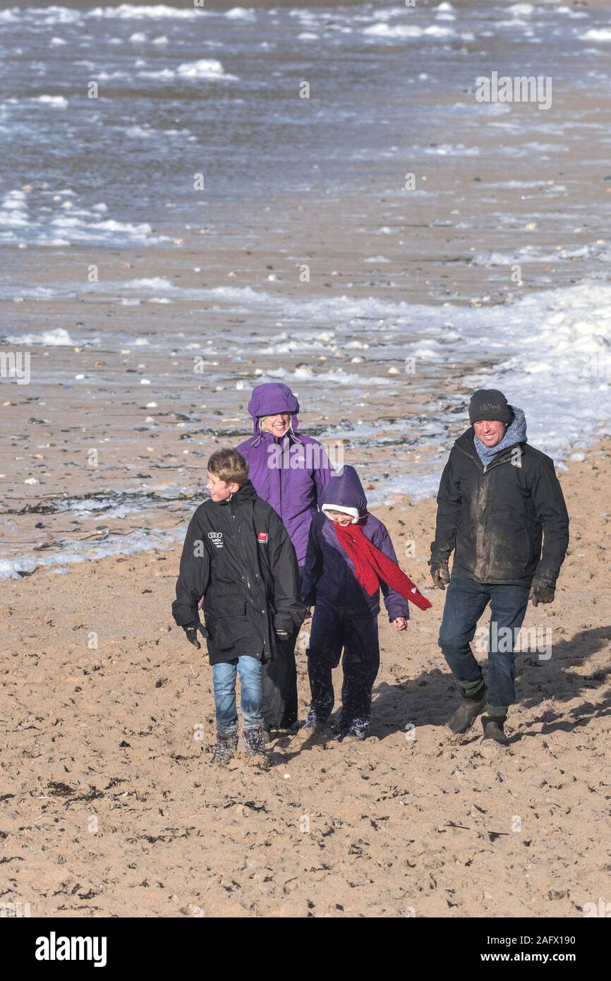 Eine Familie und ihr Hund beim Spaziergang entlang den Fistral Beach in Newquay in Cornwall. Stockfoto