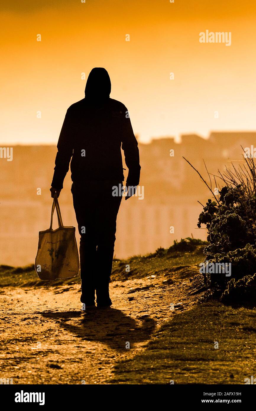 Eine Abbildung auf einem Pfad und einer Einkaufstasche durch den intensiven Abend licht. Stockfoto