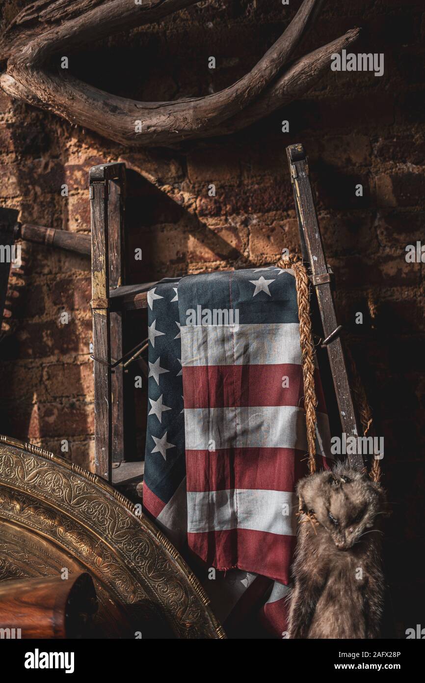 Vertikale Aufnahme der Flagge der Vereinigten Staaten hing Auf einem Metallständer in einem alten Dachboden Stockfoto