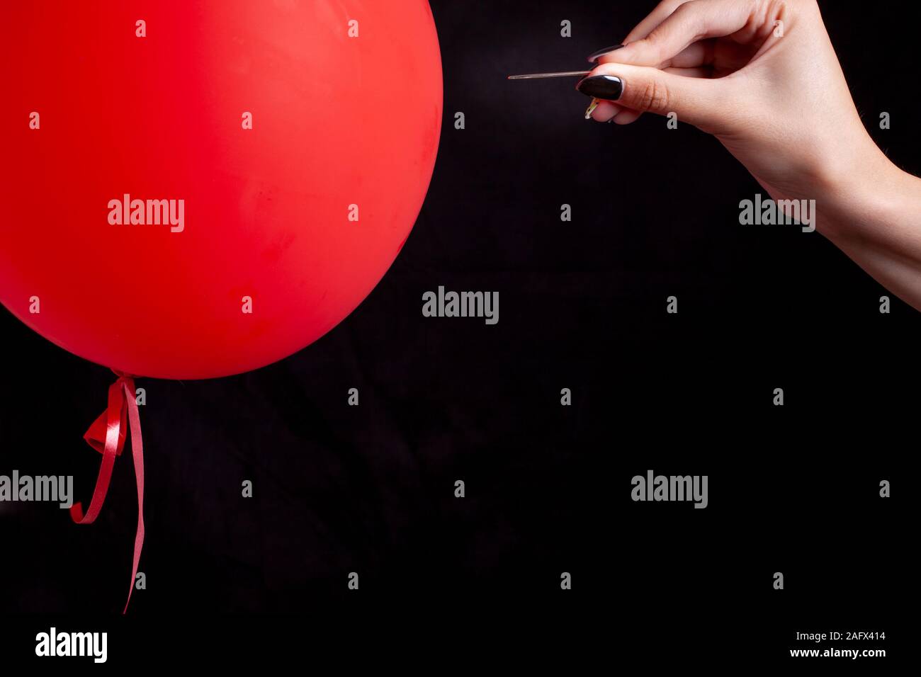 Burst Red Balloon mit einer Nadel - Gefahr Konzept Stockfoto