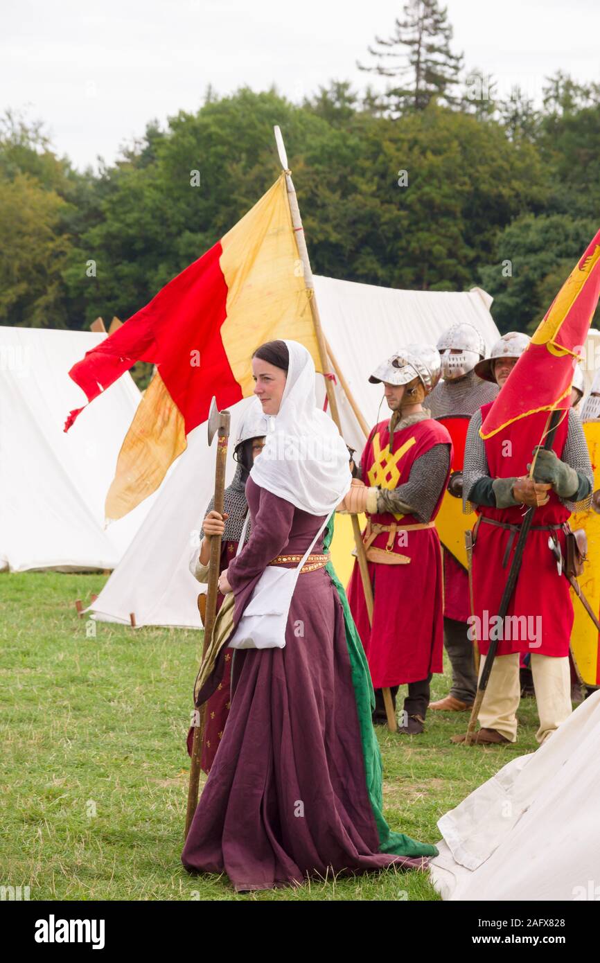 Frau gekleidet im typischen mittelalterlichen Kostüm mit Soldaten zu einem Re-enactment Camp Stockfoto