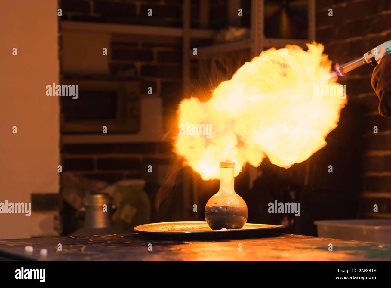 Lab Technician in Brand zu einer Kugel mit Wasserstoff Lötlampe Stockfoto