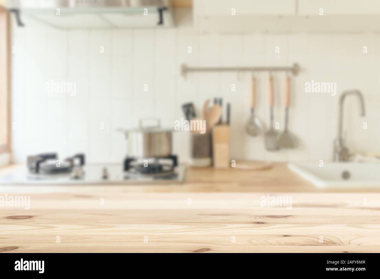 Küche Hintergrund unscharf mit hölzernen Tisch sauber Weiß für Küchenutensilien montage Werbung Banner Layout. Stockfoto