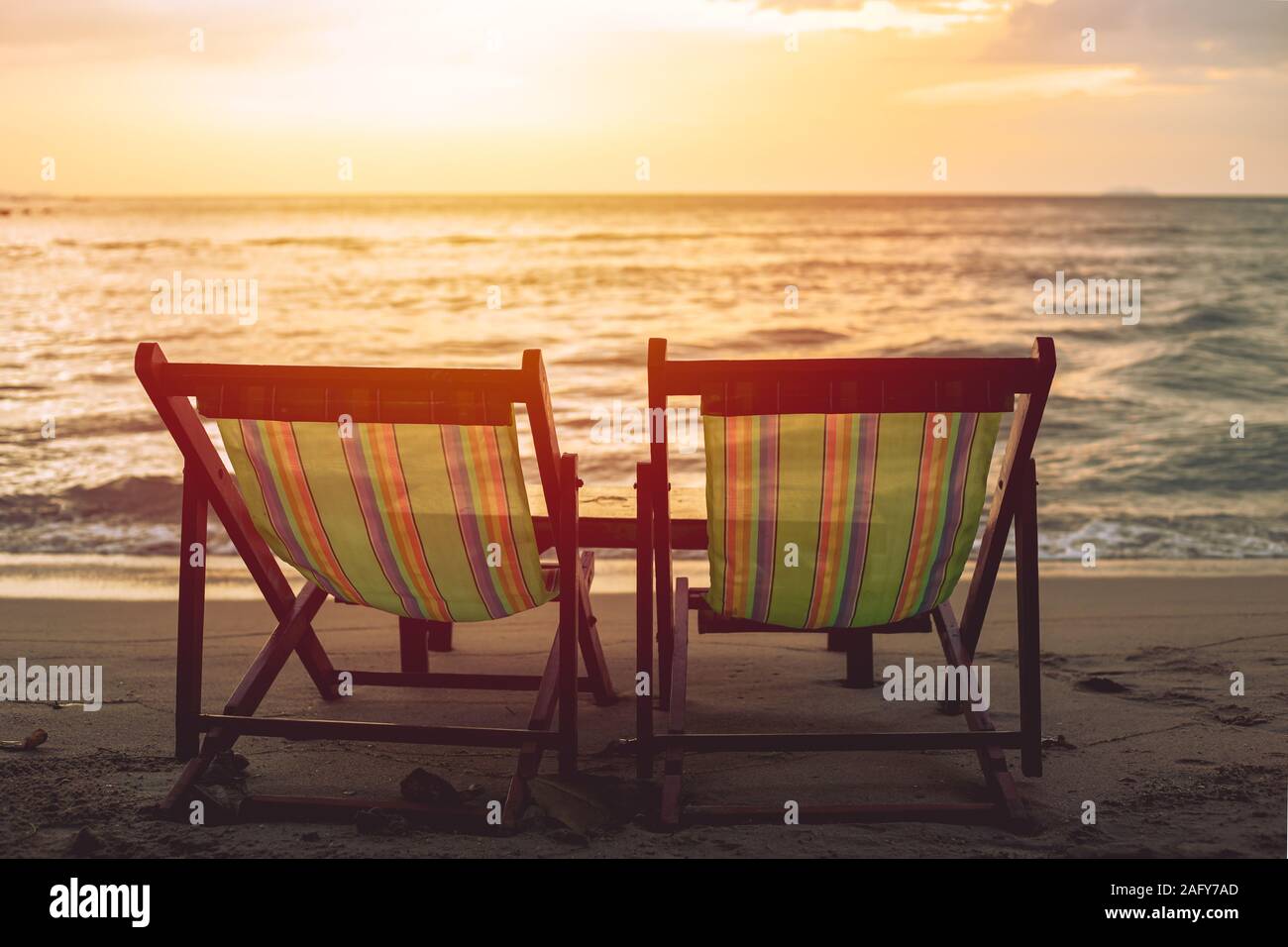 Zwei leere Strand bett Stuhl am Strand mit Sonne Dämmerung Himmel Hintergrund gesetzt. Stockfoto