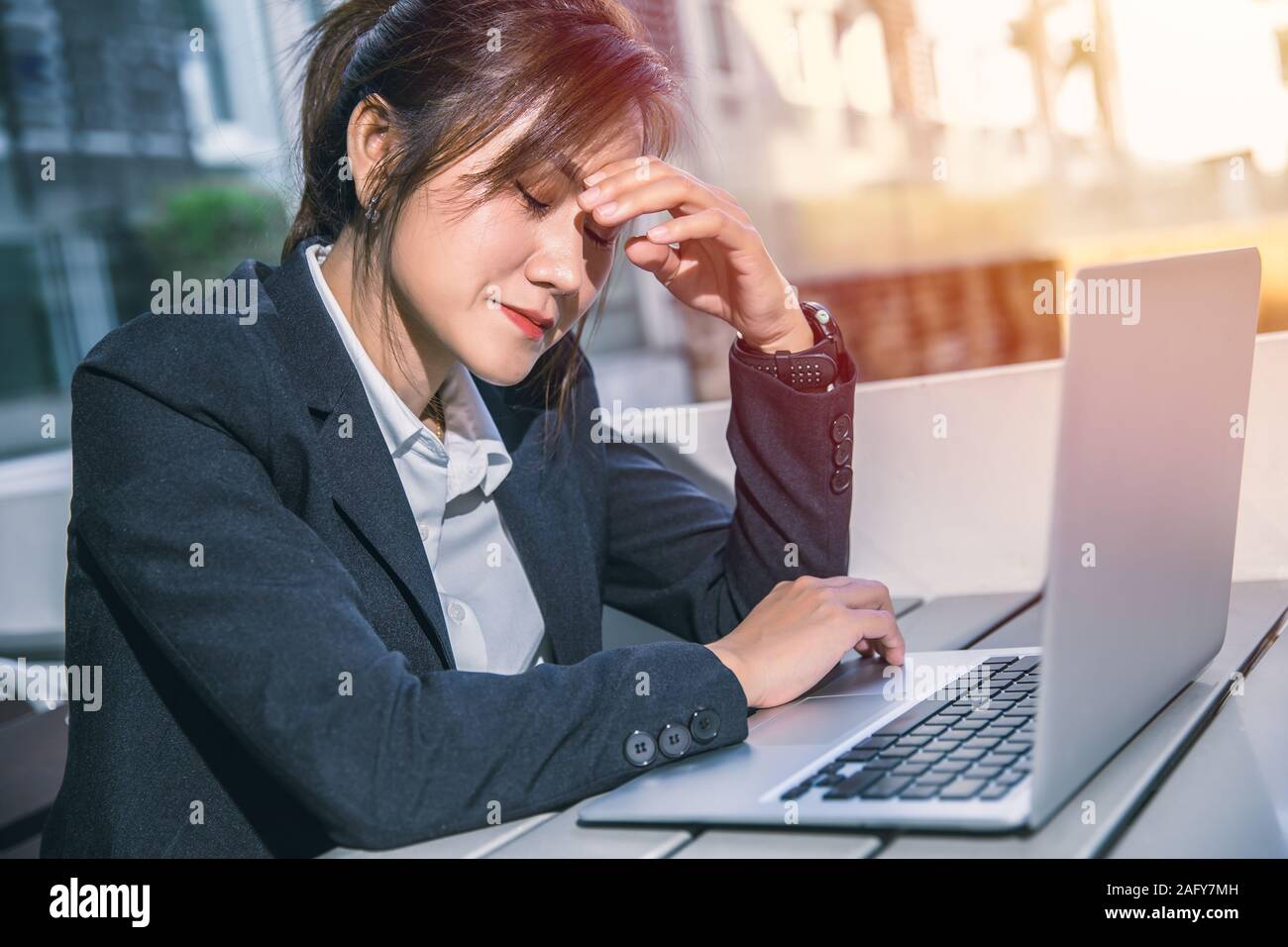 Asian Business Frau schlechte Gefühl Migräne Kopfschmerzen beim Lesen schlechte Nachrichten business Bericht vom Laptop e-Mail. Stockfoto