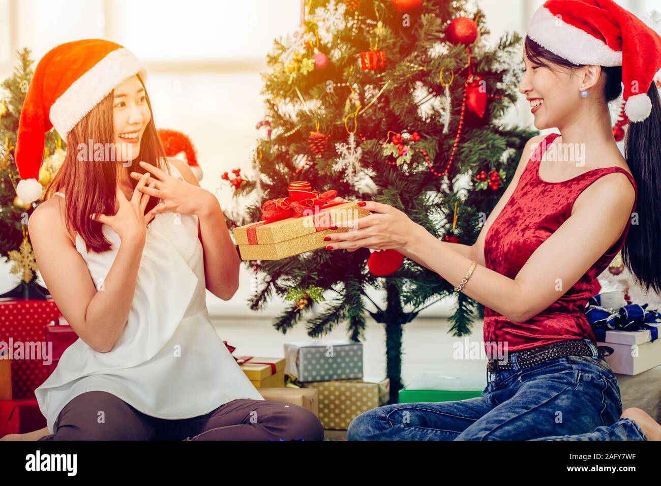 Asiatische Frau, Weihnachten Neujahr Geschenkbox präsent zu ihrer Freundin Gefühl überraschung Ausdruck. Stockfoto