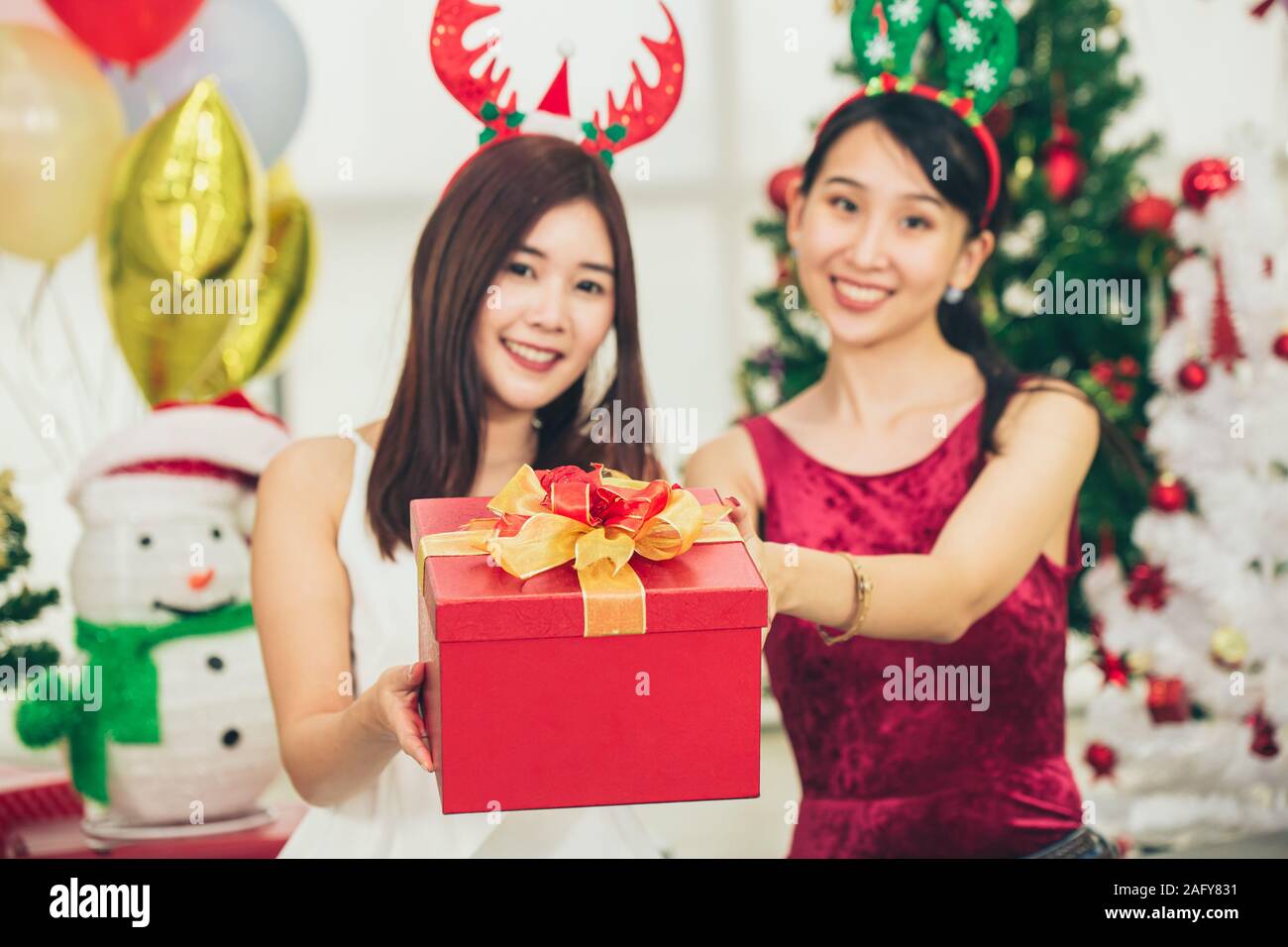 Zwei asiatische Mädchen jugendlich im Glück Weihnachten Silvester moment cellebration geben die Geschenkbox. Stockfoto