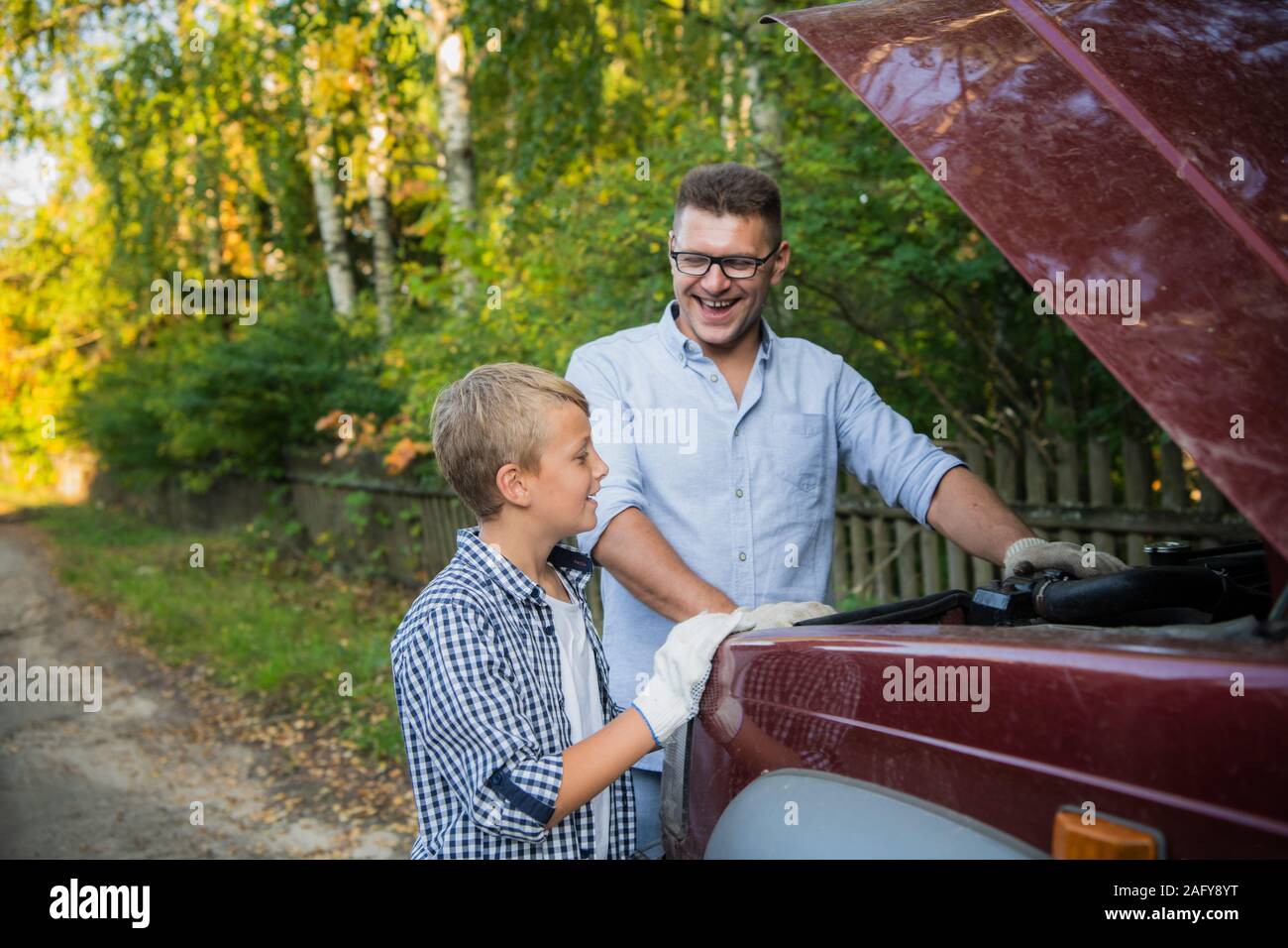 Vater Lehre, sein Sohn, wie das Öl auf der Familie Auto zu prüfen. Stockfoto