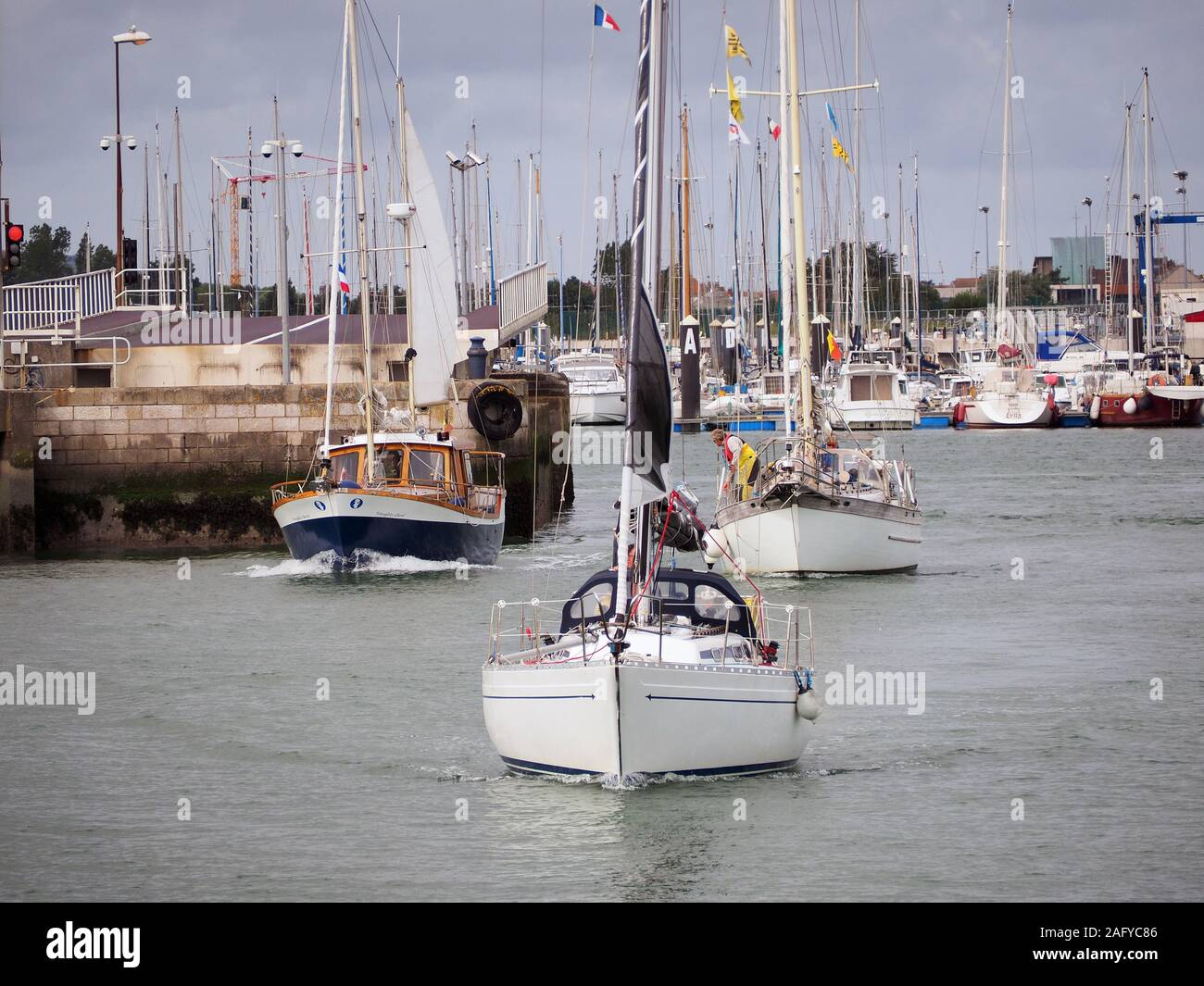 Drei Yachten lassen Sie den Eingang nach Calais Marina/Hafen in Frankreich. Stockfoto