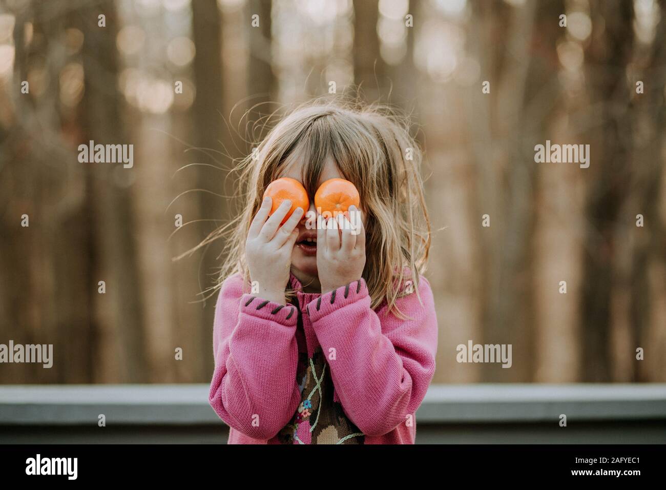 Porträt der jungen Mädchen mit Orangen über ihre Augen Stockfoto