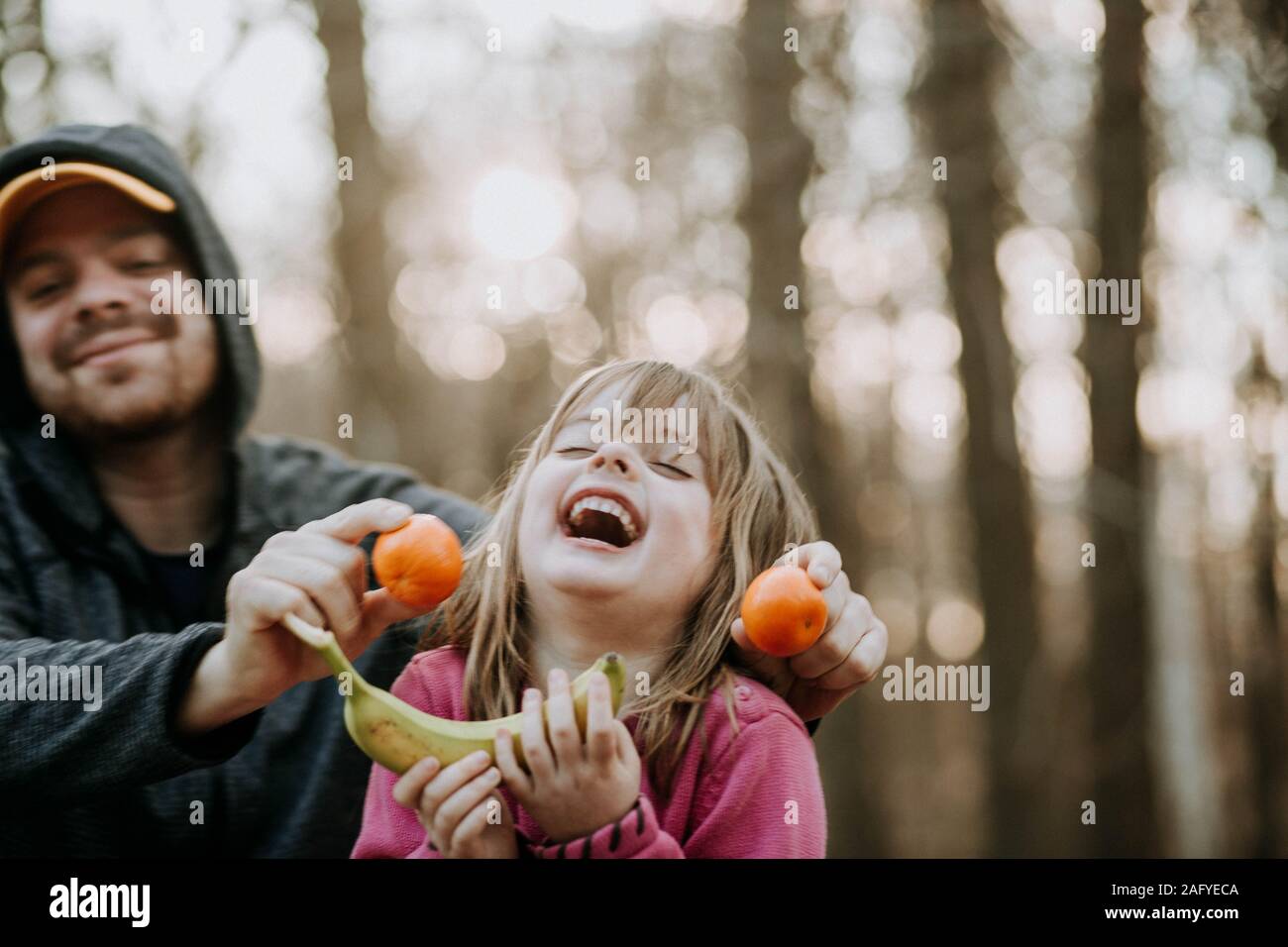 Junge Mädchen lachend mit Vati außerhalb Stockfoto
